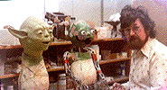 Two Yoda puppets, one with mask, one without